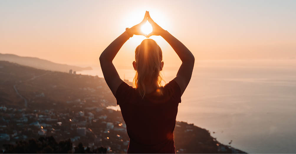 Silhouette of woman doing yoga at sunrise. Harmony, tranquility and relaxation in nature